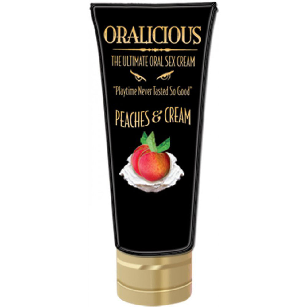 The image displays a product tube labeled "Oralicious Peaches & Cream Oral Sex Cream." The tube is black with a gold cap and features an image of a peach slice with a mint leaf on a cream background, suggesting a tasty and cooling effect.