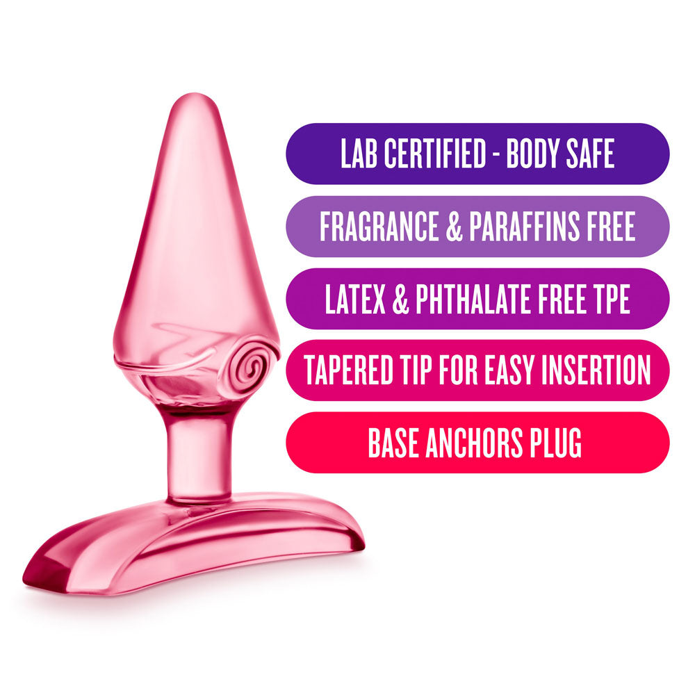 A pink, tapered anal butt plug with a flared base. The product is presented with labels highlighting its key features such as being lab certified, body safe, fragrance and paraffins free, latex and phthalate free, and having a tapered tip for easy insertion.