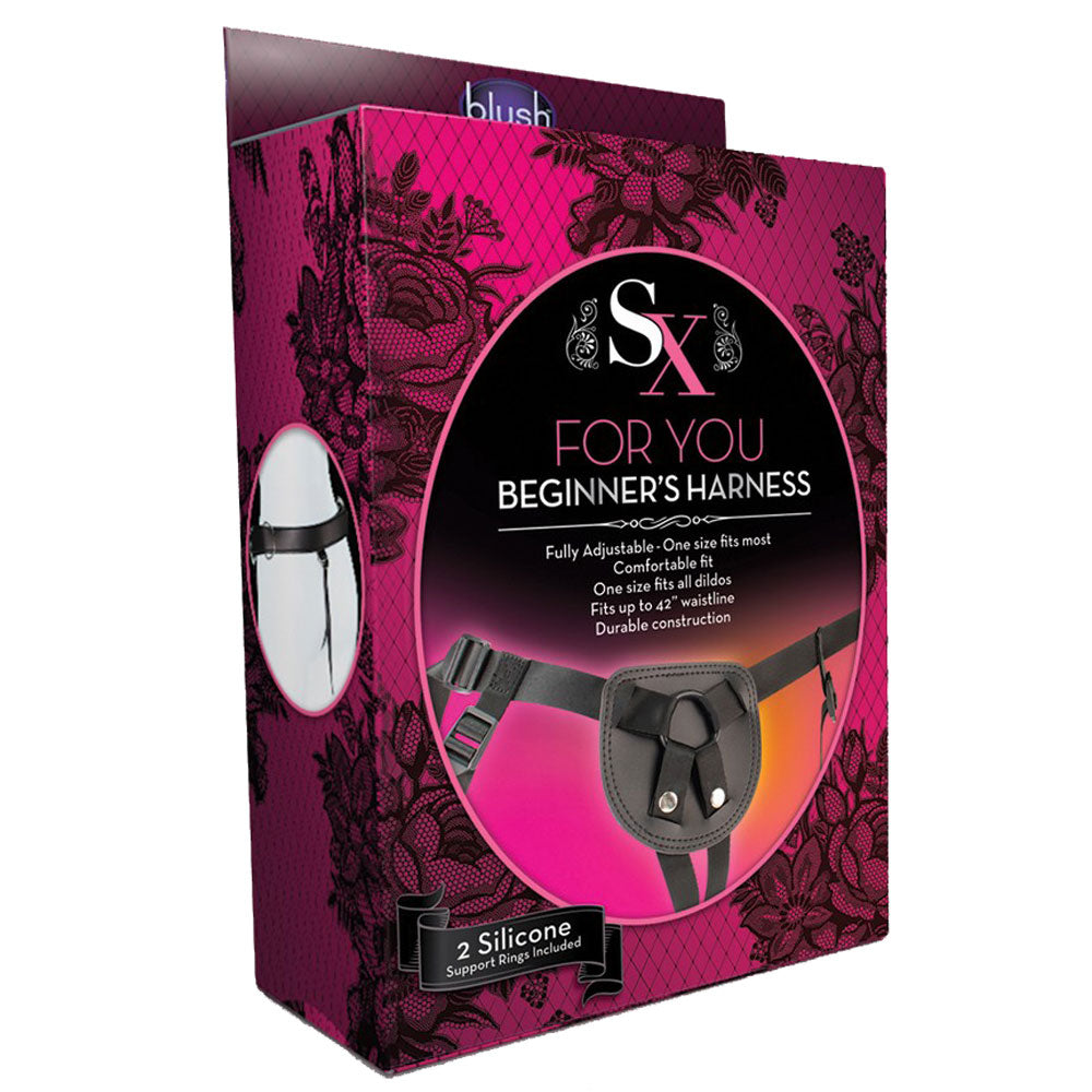 The image shows the packaging of the beginner's strap on harness, which is black and pink. The box features the product name and a visual of the harness, highlighting its adjustable straps and rings.