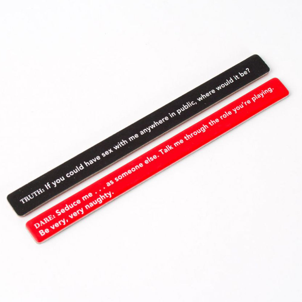 The image shows a collection of red and black sticks with written prompts for a party game called 'Sexy Truth or Dare'. shows 2 sticks on a white background