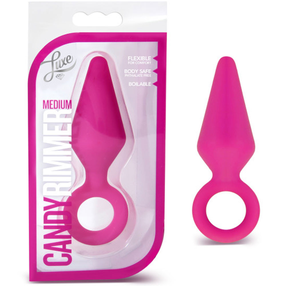 A medium-sized pink anal plug with a flared base and a removal ring, shown both in its packaging and separately. The packaging is also pink and features the product name 'Candy Rimmer' prominently.