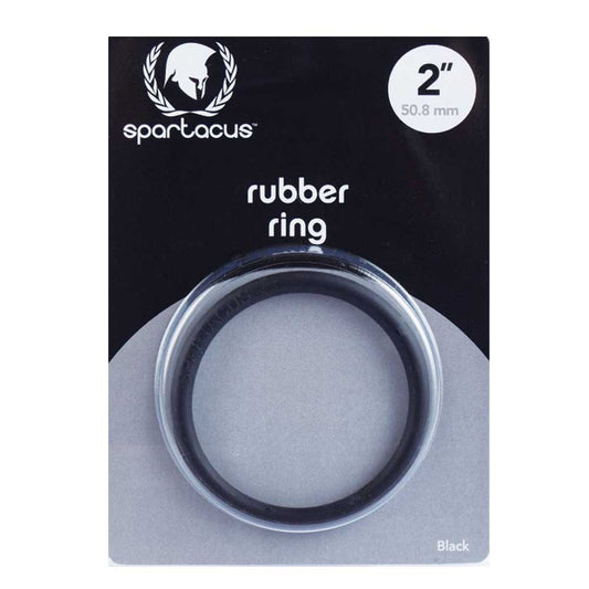 A black rubber cock ring labeled 'Spartacus' is displayed on a package, indicating a snug fit for controlling ejaculation and enhancing performance.